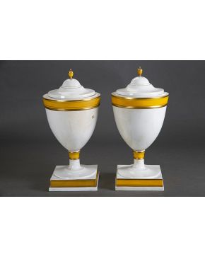 1322-Decorativa pareja de urnas con tapa en porcelana española esmaltada. s. XX.