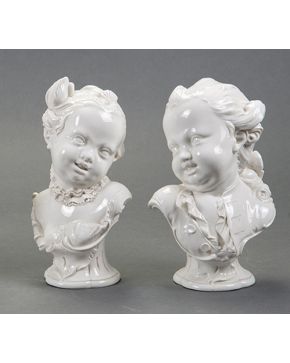 1293-Pareja de bustos de niña y niño dieciochescos en porcelana centroeuropea esmaltada en blanco.