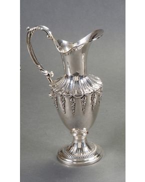 1229-Elegante jarra en plata española punzonada con marcas de Farco. Trabajo matelé y decoración relevada con ces y guirnaldas de flores. 