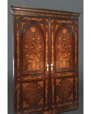 661-Exquisito armario holandés en madera tallada. con profusa decoración de marquetería formando jarrones y flores. Doble puerta con forma ojival. Al inte