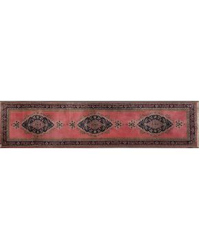511-Alfombra de pasillo persa en lana con tres medallones sobre campo en tono rosado.