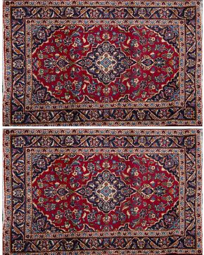 560-Pareja de alfombras persas en lana Kashan sobre campo granate.