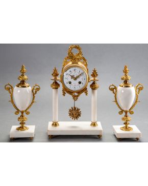 701-Reloj de sobremesa con guarnición de copas de estilo Imperio en bronce dorado y mármol blanco. Esfera sobre columnas con numeración arábiga. mecanismo