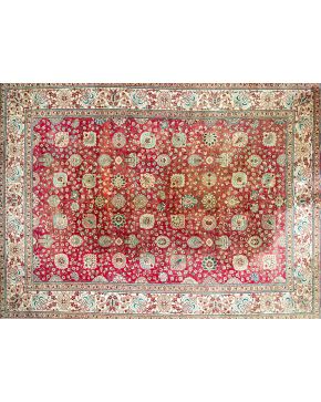 449-Alfombra persa en lana con decoración floral y vegetal sobre campo granate y cenefa en beige.