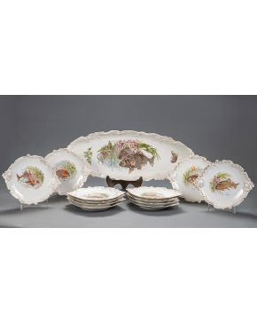 1017-Vajilla en para pescado en loza esmaltada con decoración de peces en el campo. Formado por: bandeja oval y 12 platos. s. XIX.