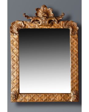 516-Espejo con marco en madera tallada y dorada con motivos de rocallas y cuadrilóbulos.