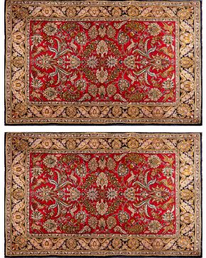 1085-Pareja de alfombras persas en lana con decoración floral y de animales sobre campo granate. 
