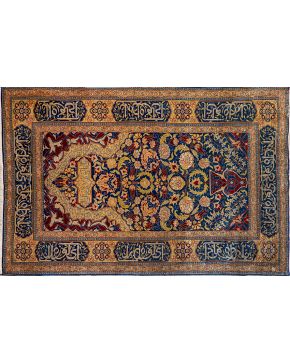 373-Alfombra persa en seda con representación de jarrón con flores. Firmas e inscripciones. Sobre campo azul oscuro con cenefas en tonos marrones. 