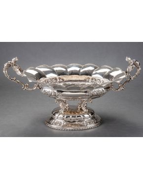579-Gran centro en forma de copa con asas en plata española punzonada con fuste de tornapuntas y decoración cincelada de rosas. Borde de contario de perla
