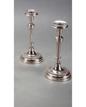 363-Pareja de candeleros en plata punzonada. posiblemente Cádiz. s. XIX. Con marcas. Decoración de contario de perlas en la base. Un fuste suelto. 