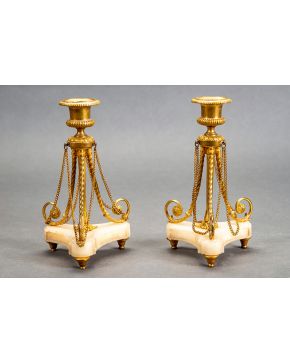 615-Pareja de candeleros estilo Imperio. s. XIX. En bronce dorado y mármol crema. Con fuste de trípode.