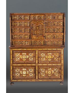 874-Gran bargueño tipo salmantino en madera y hueso con abigarrada decoración de talla y policromía. Portezuela central rematadas en frontón de volutas y 
