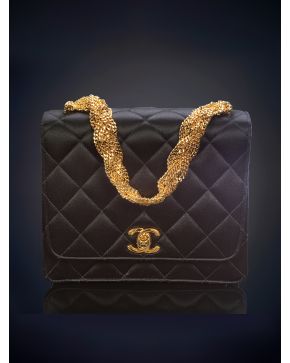 757-TIMELESS CHANEL Bolso de mano en seda negra diseño acolchado en rombos y cierre con las iniciales de la firma en dorado. Bella cadena renzada. Caja y estuche originales.