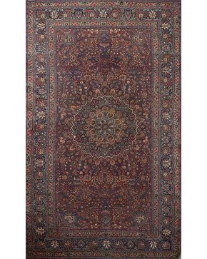 783-Gran alfombra persa en lana con florón central. representación de jarrones y decoración vegetal y floral sobre campo granate. 