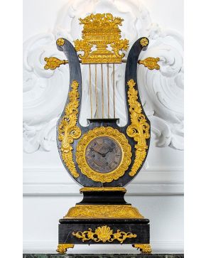 735-Reloj de sobremesa francés tipo lira, realizado en madera ebonizada y con monturas en bronce dorado, c. 1860.