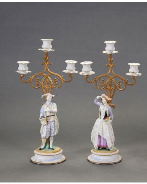 2003-Pareja de candelabros en porcelana, biscuit y metal dorado. De tres luces. Representando dama y caballero. Altura: 48 cm.