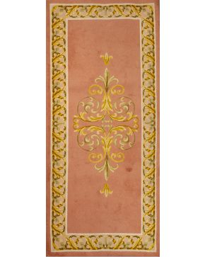 955-Alfombra en lana de nudo español hecha mano diseño neoclásico de Miguel Stuyck. Sobre campo color salmón con decoración de roleos vegetales en verde y dorado.   Medidas: 140x315 cm.