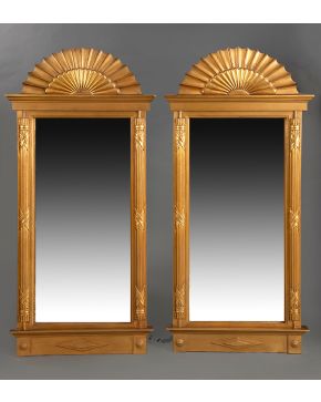 787-SIGUIENDO MODELOS SUECOS. Decorativa pareja de espejos en madera tallada y dorada. Remate semicircular en forma de abanico. Medidas: 167 x 76 x 6 cm.