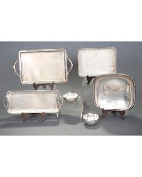 306-Lote de dos bandejas en plata española punzonada: una rectangular con asas e inscripciones grabadas en el campo y otra tipo tarjetero con asas en plata lisa con marcas de Durán.  Peso: 1 Kg.