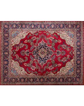 784-Gran alfombra persa en lana con decoración vegetal y profuso motivo geometrico central en tonalidades verdes, azules y rosadas sobre campo granate.  Medidas: 330x252 cm.