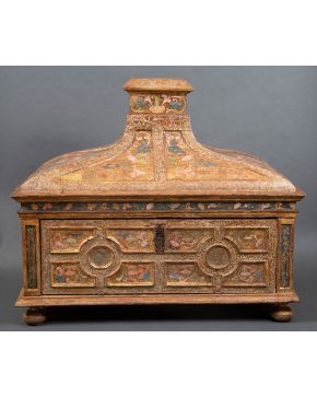 587-ESCUELA CASTELLANA S.XVI  Arqueta en madera tallada y policromada con tapa en forma troncocónica y decorada con formas y líneas geométricas talladas.  Medidas: 78x89x49 cm 