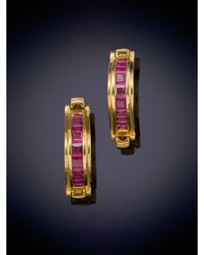 23-ELEGANTES GEMELOS DE RUBÍES CALIBRADOS sobre una montura triangular de oro amarillo de 18k. 