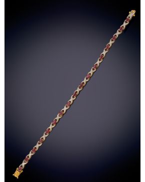 24-ELEGANTE PULSERA DE RUBÍES TALLA OVAL UNIDA POR ASPAS DE PEQUEÑOS BRILLANTES. Montura de oro amarillo de 18k. 