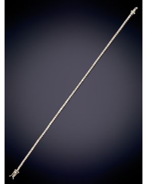 51-ELEGANTE RIVIERE DE DIAMANTES MONTADOS EN GARRA sobre una montura en oro blanco de 18K.