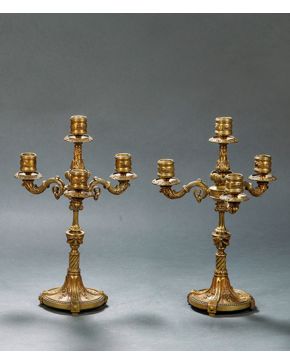 2136-Pareja de candelabros de cuatro luces en bronce dorado, s. XIX. Decoración relevada de contario de perlas, elementos vegetales y uvas. Altura: 35