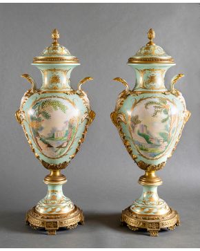 951-Decorativa pareja de grandes jarrones con tapa en porcelana esmaltada de Sèvres sobre fondo verde agua con detalles en dorado. Escenas clásicas y 