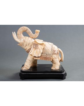 448-Elefante de la suerte en hueso tallado y pirograbado sobre peana de madera. Medida: 33x30 cm.