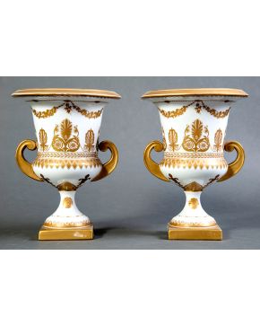 870-Pareja de jarrones Medici en porcelana centroeuropea blanca con decoración de palmetas y guirnaldas en dorado. Una consolidada. Altura: 29 cm.