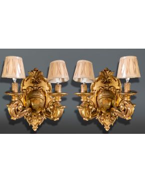 873-Pareja de apliques de dos luces en madera tallada y dorada con decoración de motivos vegetales y tornapuntas. Altura: 44 cm. 