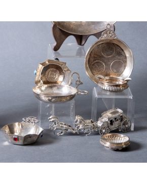 334-Variado lote en plata punzonada formado por siete piezas: carroza en plata 915, ceniceros y catavinos con bases de monedas, trabajo mart