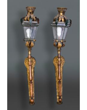 317-Decorativa pareja de faroles en madera y metal pavonado y dorado con decoración de palmetas y remate de coronas. Altura: 120 cm.