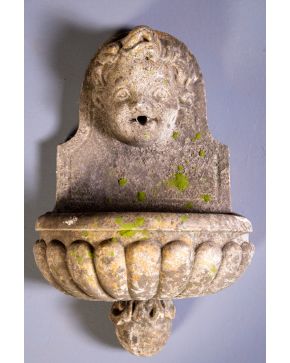 301-Fuente de jardín en arenisca con cabeza de querubín y pila en forma de venera. Altura: 65 cm. aprox.