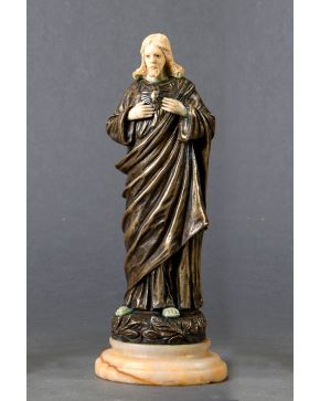 351-Sagrado Corazón de Jesús, ca. 1900.  Escultura crisoelefantina en bronce y marfil tallado. Sobre peana en alabastro. Firmada. Con ce