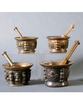 339-Lote formado por cuatro morteros españoles, s. XVI-XVII, de costillas y mascarones en bronce. Con majaderos. Altura mayor: 12 cm.