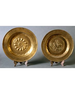 337-Dos platos limosneros en bronce dorado, s, XVII, con inscripciones y decoración grabada y relevada. Uno con motivo geométrico concéntric