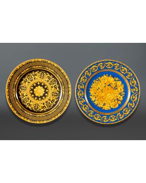 347-VERSACE Lote de dos platos en pocelana con detalles en amarillo, negro y azul decorado con flores y formas ondula
