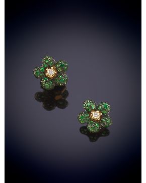 85-BELLOS PENDIENTES CON DISEÑO DE FLOR CUAJADA EN ESMERALDAS Y UN BRILLANTE CENTRA