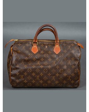 985-LOUIS VUITTON Modelo Speedy", en lona marrón con remates en cuero. Con desperfec