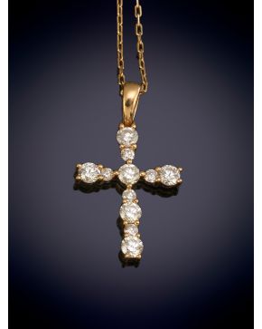 37-ELEGANTE COLGANTE CRUZ DECORADO POR BRILLANTES DE 0,43CT sobre una montura y con cadena en oro amarillo de 18K.