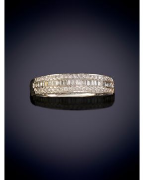 43-ELEGANTE SORTIJA CON UNA HILERA DE DIAMANTES TALLA BAGUETTE ENMARCADA POR DOS LÍNEAS DE BRILLANTES sobre una montura en oro blanco de 18K.