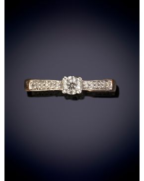 45-ELEGANTE SORTIJA CON UN BRILLANTE CENTRAL FLANQUEADO POR BRILLANTES sobre una montura en oro rosa de 18k.