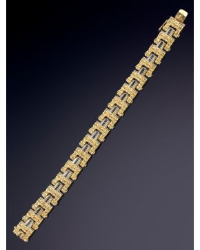 51-PULSERA ANTIGUA DE ESLABONES CON DISEÑO FLORAL DECORADA POR ZAFIROS CALIBRADOS. Montura en oro amarillo de 18K.