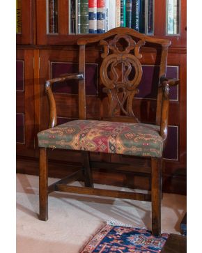 376-Butaca inglesa estilo Chippendale, s. XIX, en madera tallada con respaldo calado y tapicería estampada.  Altura: 96 cm.
