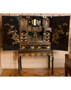 357-Cabinet on stand" chino para la exportación, s. XIX, en madera lacada negra y dorada "japanning". Cuerpo superior con puertas batientes y, al inte