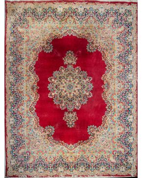 399-Alfombra persa Naim en lana con profusa decoración floral en campo sobre fondo granate y bordura con tornapuntas en dorado.  Medidas: 316 x 407 cm