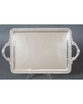 1017-Elegante bandeja rectangular con asas en plata española punzonada. Perímetro acanalado.  Peso: 1,150 Kg. Medidas: 30,5x51 cm.